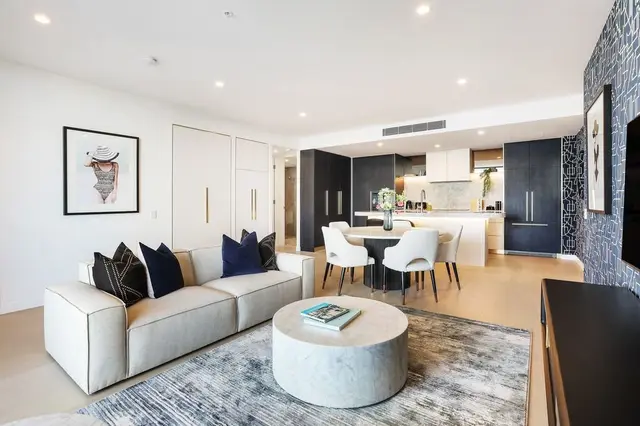 Living room with cream sofa, round marble coffee table and dining setting beyond