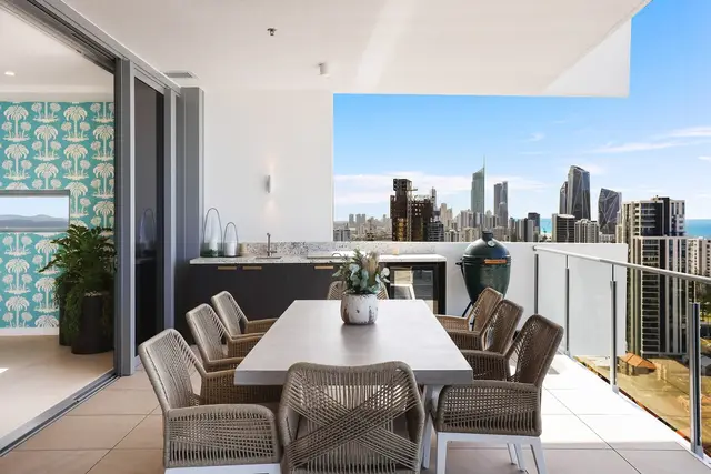 Bedroom balcony with black ribbed chair, glass balustrade and coastal high-rise ocean views