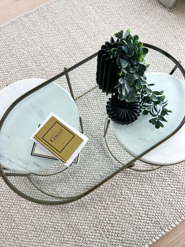 Marble nesting coffee tables with Gucci book, black origami vase and succulents on jute rug