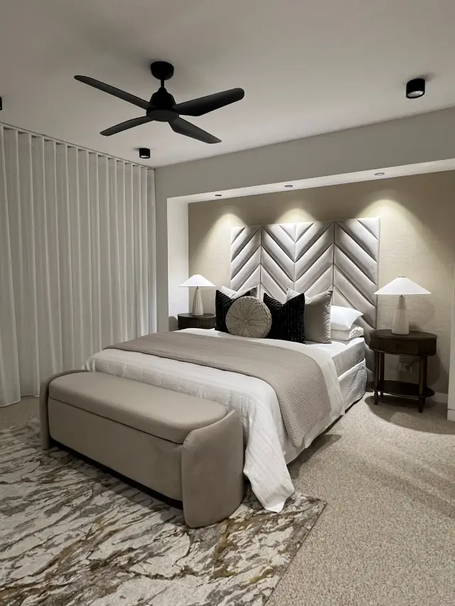 Master bedroom with chevron upholstered bedhead, taupe linen bedding and marble-pattern rug