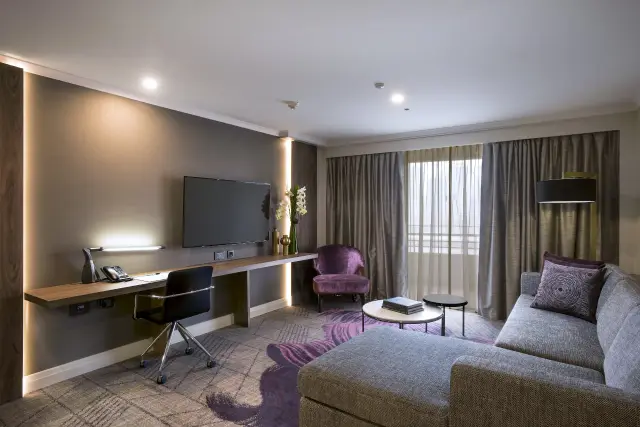 Suite lounge with built-in timber desk, task lighting and modular sofa